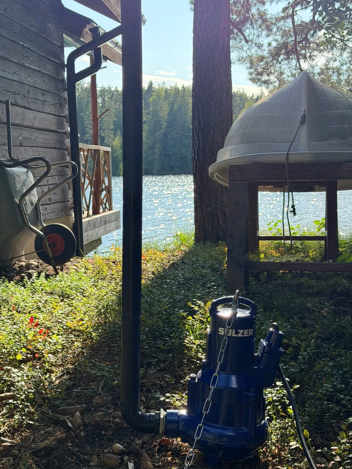 Uusi sininen uppopumppu paineputkineen ja nostoketjuineen kohteessa ennen asennusta