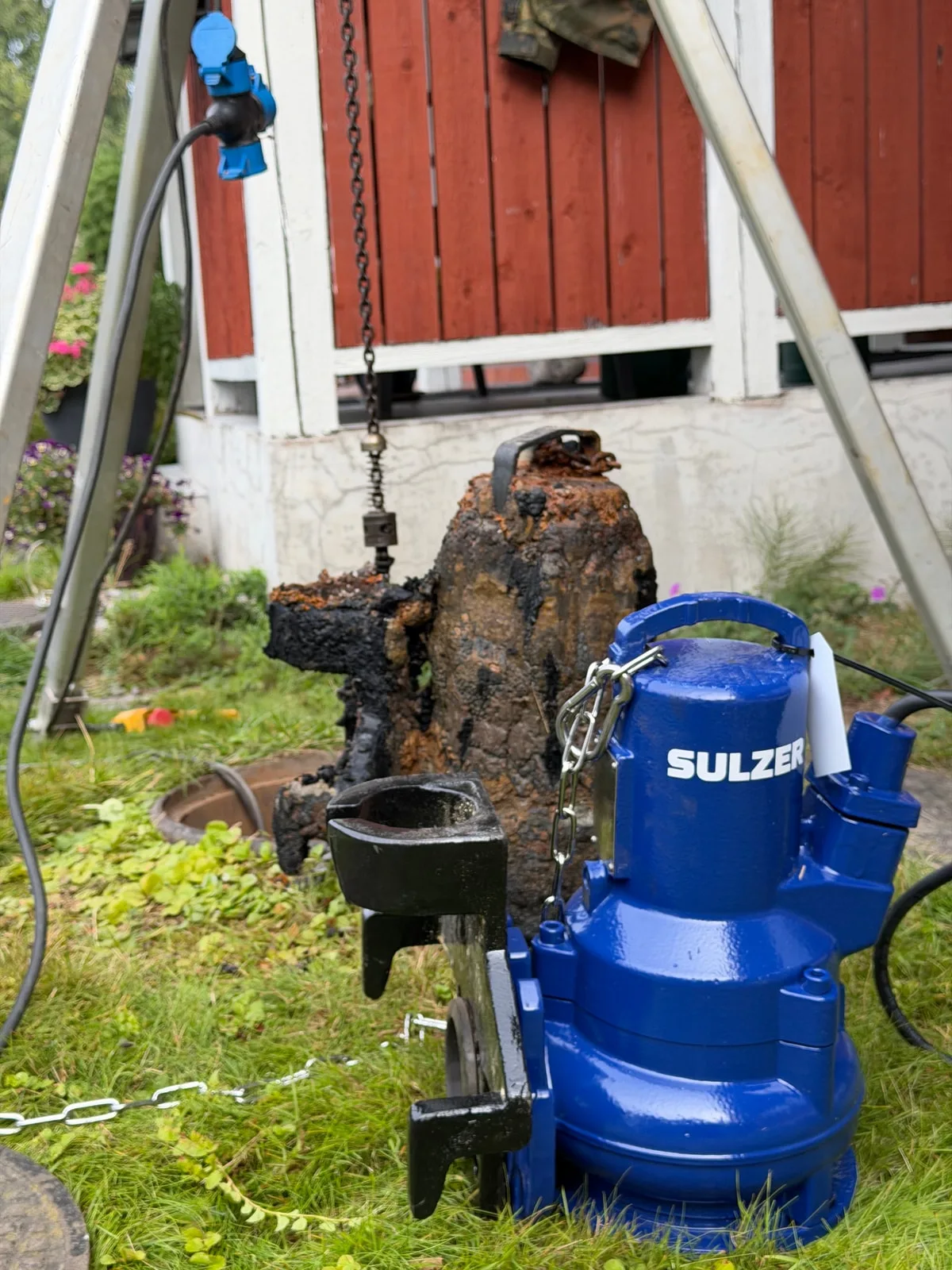 Kaivosta nostettu vanha pumppu ja uusi sininen uppopumppu vierekkäin ennen asennusta